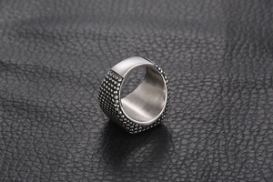 Macro d'une bague punk en acier titane avec texture granulée et surface polie brillante