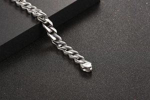 Dettaglio macro del bracciale a catena in acciaio al titanio con chiusura a scatto