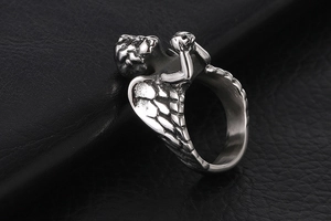 Détail macro d'une bague ange gothique avec crâne sur une texture en cuir noir