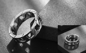 Macro shot of silver men's chain ring with industrial polished steel link texture