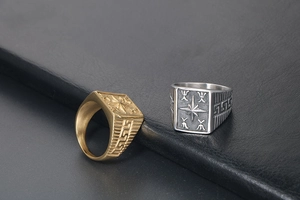 Close-up of vintage steel signet rings with embossed star and Greek key patterns