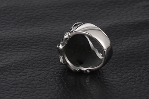 Macro detail of vintage stainless steel ring featuring intricate side animal relief carving