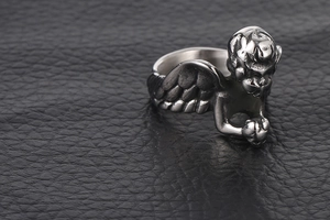 Vue détaillée d'une bague ange vintage en argent avec gravure complexe sur cuir noir élégant