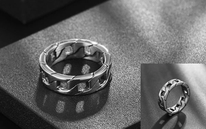 Macro shot of silver titanium steel Cuban link chain ring with polished industrial finish