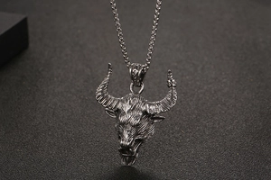 Detailed view of a silver bull head pendant necklace with intricate punk rock textures