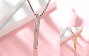 Detailed close-up of twisted square bar pendant in polished silver and gold finish