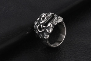 Detail of vintage stainless steel lion ring with intricate 3D carvings on black leather