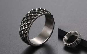 Detail of vintage titanium steel ring with intricate 3D dragon scale texture and polished finish