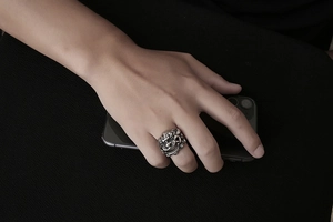 Close-up of vintage stainless steel lion head ring worn by model in punk style