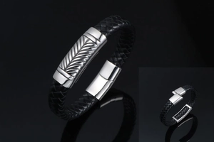 Detailed view of men's braided leather bracelet with engraved steel clasp mechanism