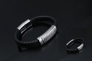 Macro detail of men's braided black leather bracelet with textured silver magnetic clasp