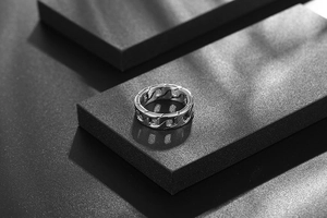 Detailed view of silver titanium steel cuban chain ring on black matte display block