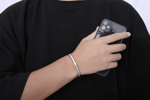 Polished silver twisted cuff bracelet shown on wrist for scale and fit details