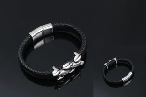 Close-up of black braided leather bracelet with silver metal buckle on mirror background