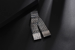 Macro detail of men's titanium steel bracelet with brick pattern clasp and blue woven texture