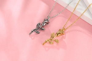 Détail des pendentifs rose en finitions or et argent avec chaînes élégantes sur soie
