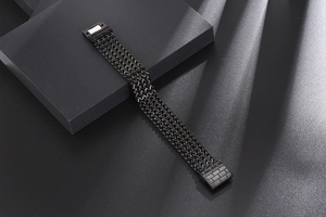 Close-up of men's black woven titanium steel bracelet with textured magnetic buckle clasp