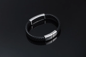 Macro shot of men's black braided leather bracelet with polished silver metal buckle