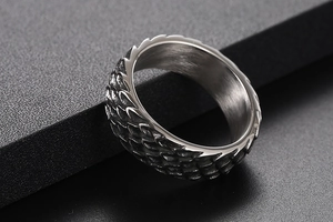 Macro shot of stainless steel ring featuring intricate dragon scale texture and polished inner