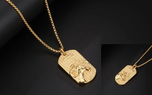 Macro view of Aries zodiac relief on golden rectangular pendant with textured finish