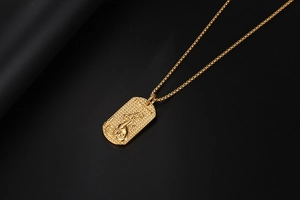 Primer plano del colgante de leopardo dorado con relieve detallado y cadena de caja