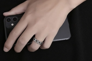 Detail of silver Cuban chain ring in titanium steel on hand with a rugged design