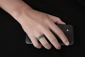 Detailed view of vintage wide titanium steel ring with textured scale pattern on hand