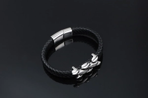 Detail of black braided leather men's bracelet with polished silver magnetic clasp