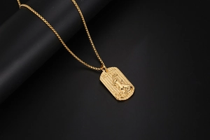 Detalle del collar de Capricornio dorado con colgante de leopardo sobre fondo negro