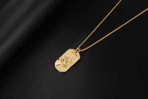 Macro view of golden Aries zodiac pendant featuring a detailed ram head relief and fine texture
