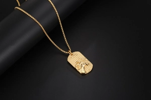 Macro view of gold Aries zodiac dog tag necklace with embossed ram head and texture