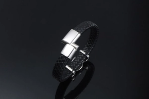 Macro detail of braided black leather bracelet with polished silver stainless steel clasp