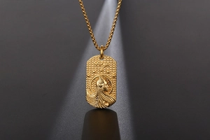 Gros plan du pendentif zodiaque Vierge doré avec relief détaillé du profil féminin