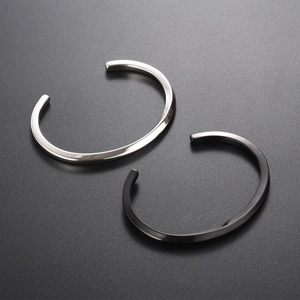 Minimalist twisted open cuff bracelet set in polished silver and matte black steel