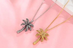 Detailed view of bicolor palm tree pendants in vintage silver and gold plating