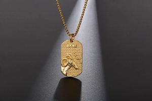 Macro shot of gold Aries zodiac pendant with textured finish and ram head relief