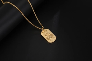 Gros plan du pendentif Cancer doré avec texture mate et design rectangulaire en relief