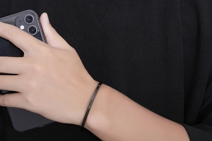 Polished black stainless steel minimalist C-shape bangle bracelet worn on wrist