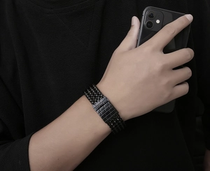 Macro shot of men's black stainless steel woven bracelet with rectangular magnetic clasp