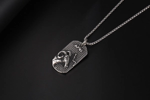 Macro view of Aries zodiac sign relief on silver matte titanium steel military tag necklace
