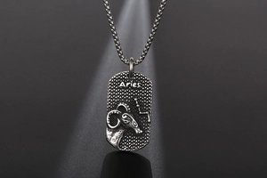 Detail of vintage Aries zodiac pendant necklace with engraved ram and star constellation
