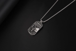 Detail of silver Taurus pendant with hammered texture and 3D bull relief on black background