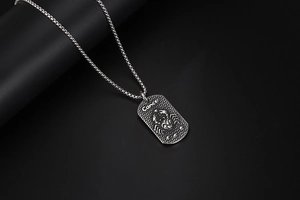 Vue macro du pendentif signe du zodiaque Cancer argenté avec relief sur chaîne en acier