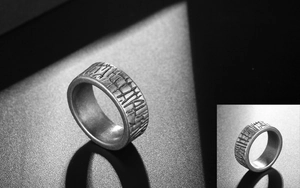 Detailed close-up of a wide titanium steel ring with vintage tree bark textured finish