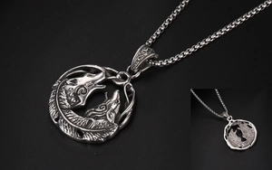 Détail macro du pendentif loup vintage avec motifs plumes et finition métal antique