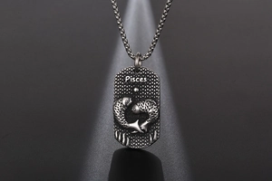 Détail du pendentif astrologique Poissons en argent vintage avec relief et chaîne
