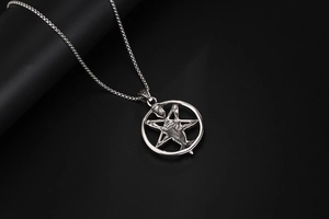 Close-up of gothic satanic goat skull and inverted pentagram pendant on a box chain
