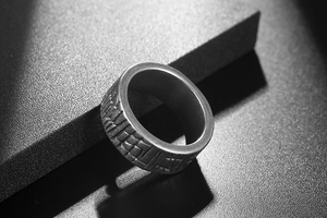 Macro shot of men's vintage wide steel ring with geometric stripes and silver finish
