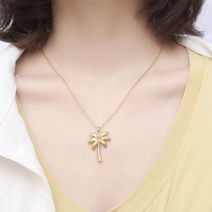 Exquisite two-tone coconut palm tree necklace pendant in gold on a female model