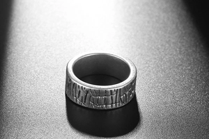Macro shot of titanium steel ring featuring realistic tree bark and rock textures